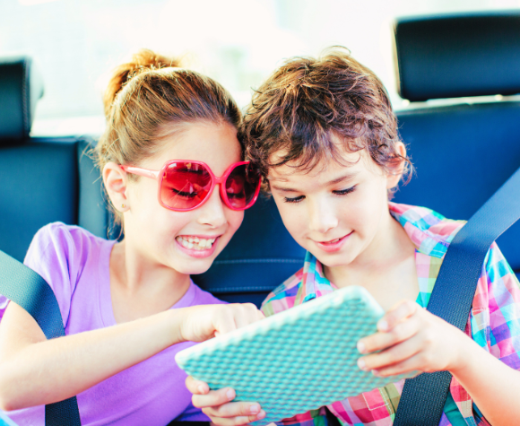 Kids entertaining themselves with a tablet in the car